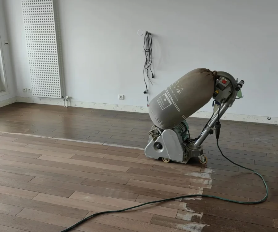 Huilage parquet en cours de réalisation par 2M Parquet Net — finition foncée avec rouleau et bidon de produit professionnel