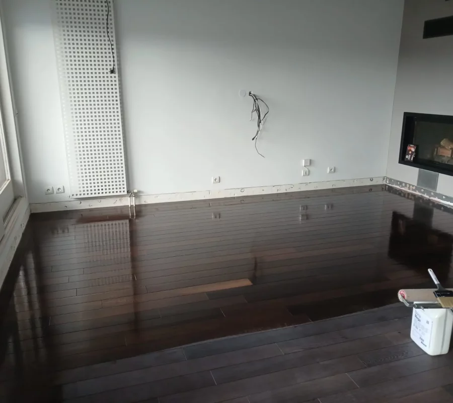 artisan appliquant de l'huile sur un parquet massif chêne en Haute-Savoie"
