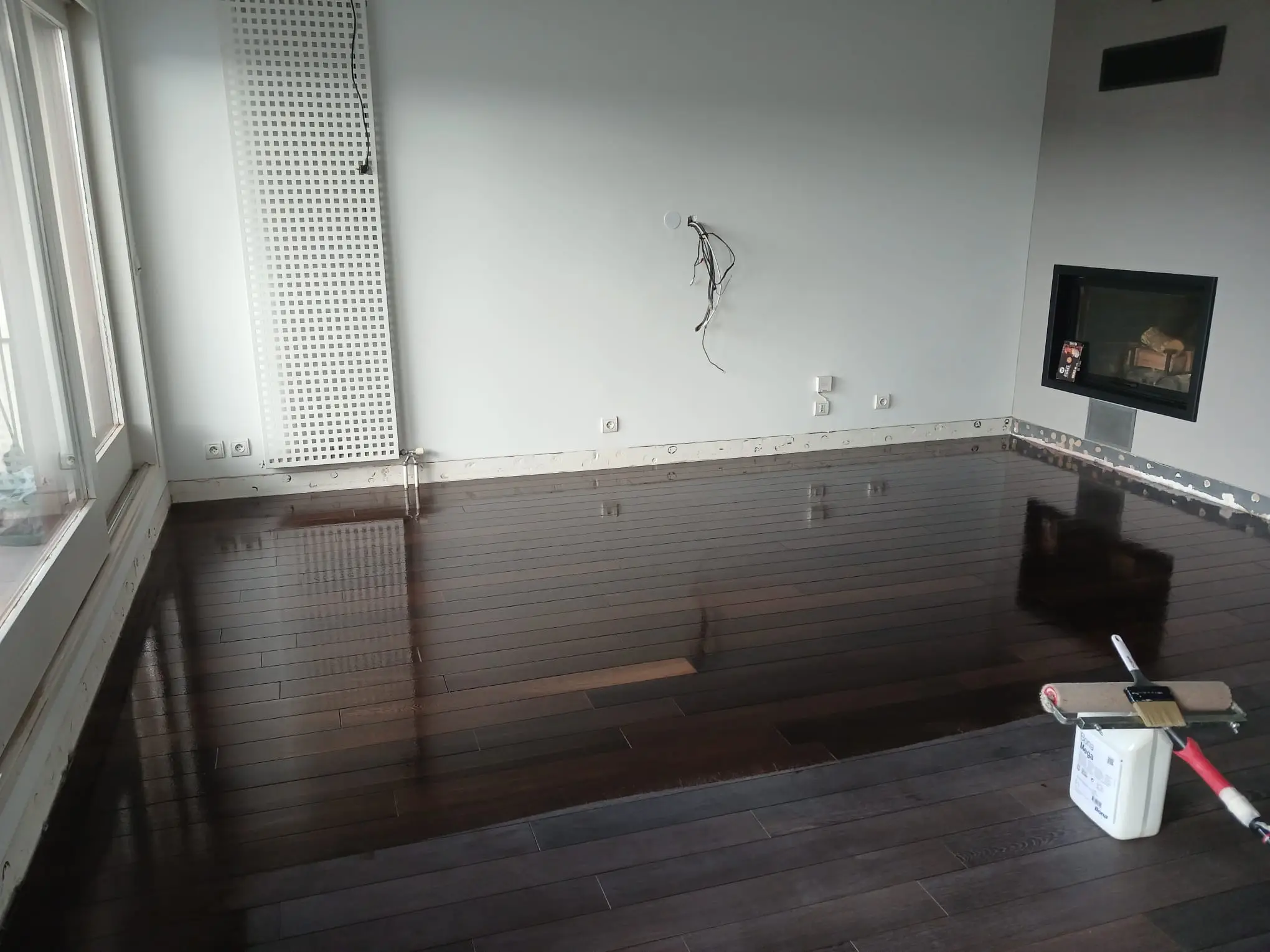 artisan appliquant de l'huile sur un parquet massif chêne en Haute-Savoie"