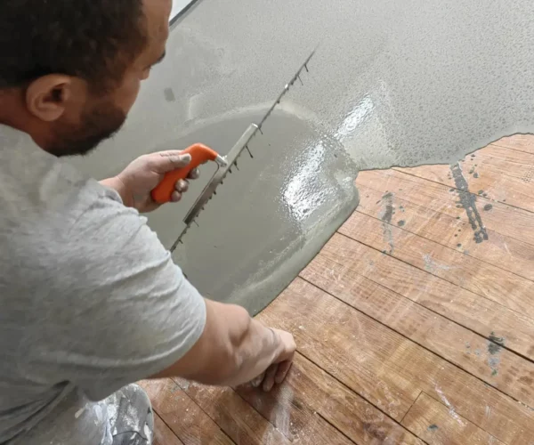 Artisan 2M Parquet Net appliquant un ragréage autonivelant sur ancien parquet bois