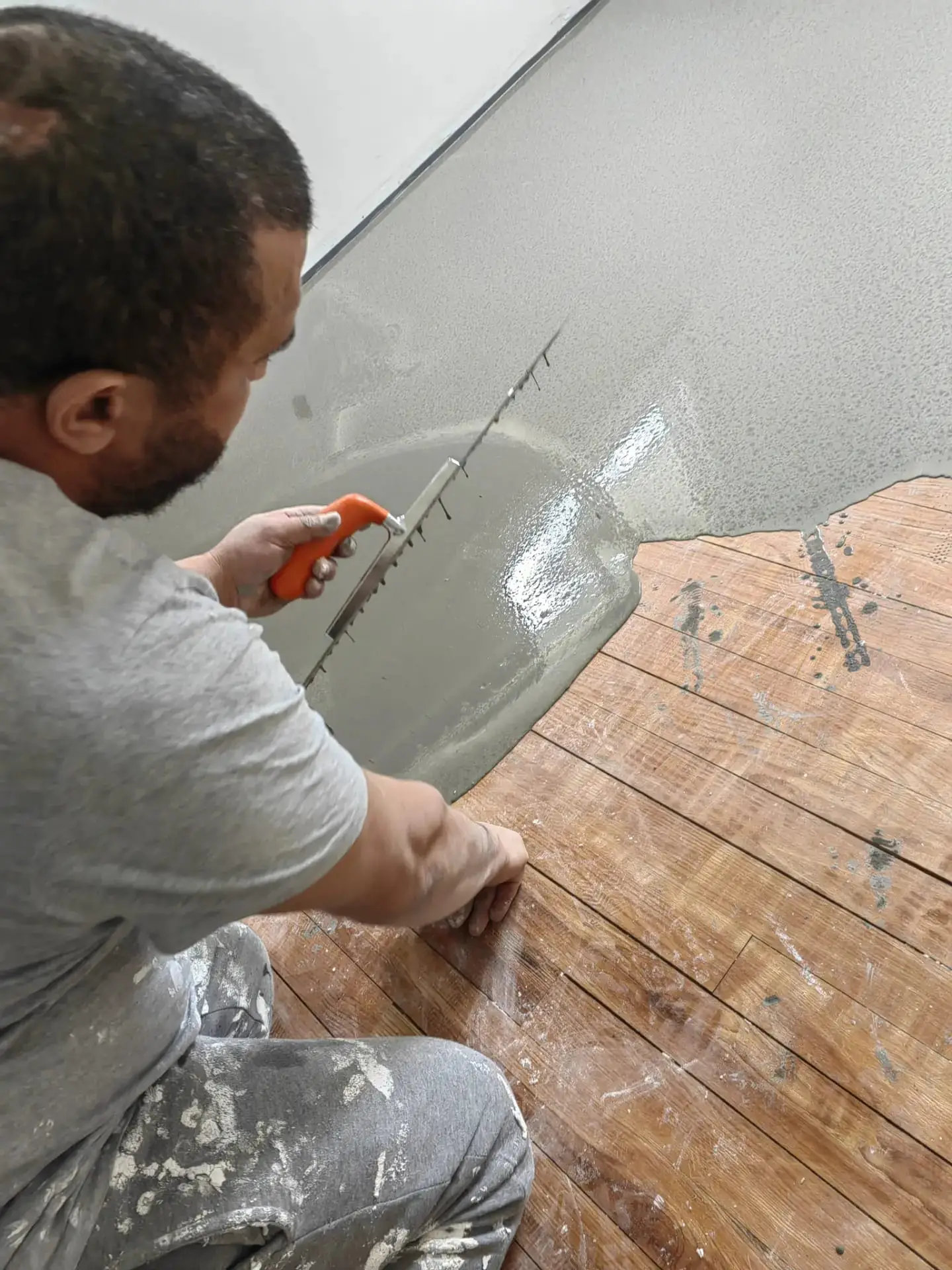 Artisan 2M Parquet Net appliquant un ragréage autonivelant sur ancien parquet bois